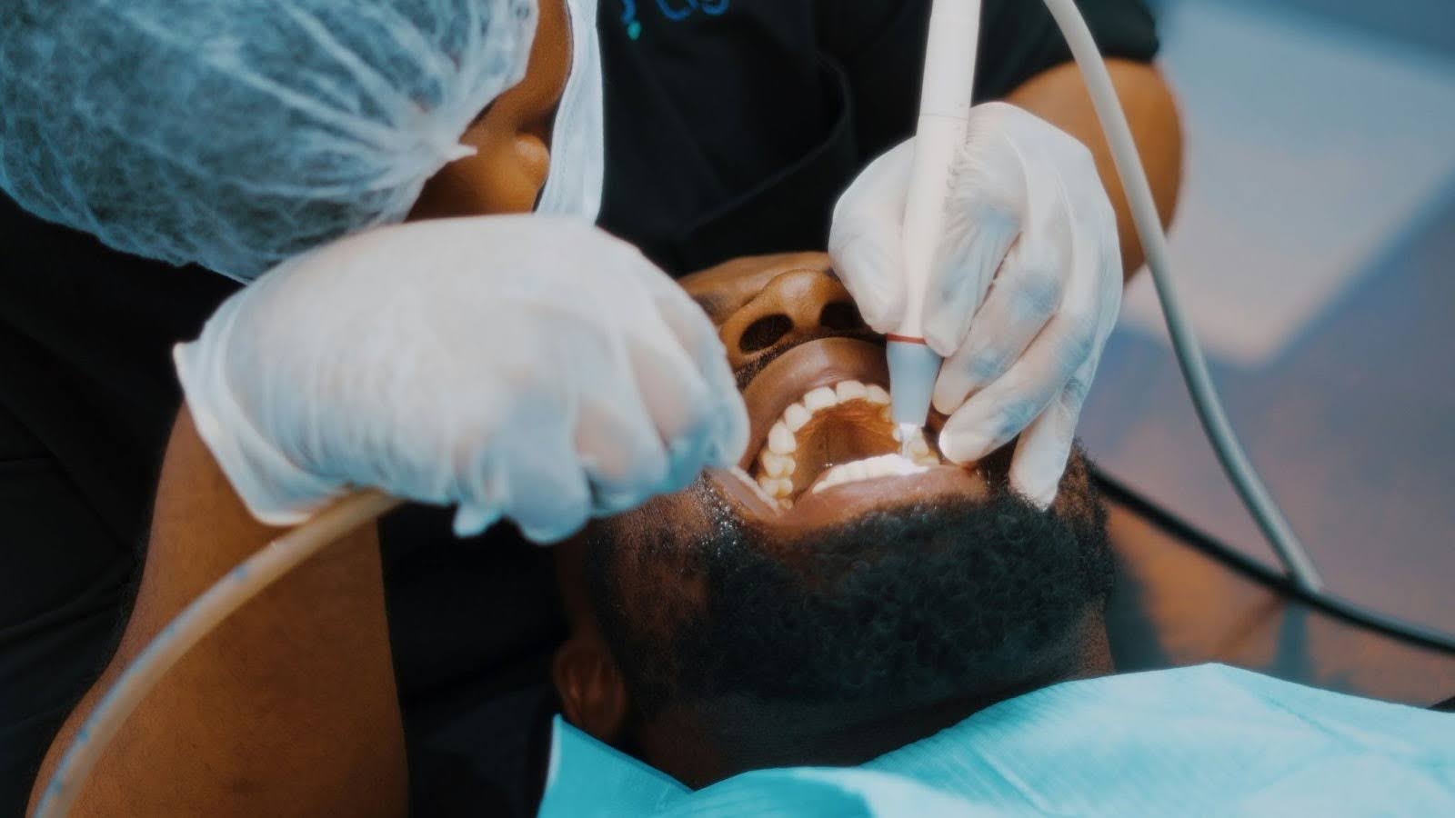 A man fixing his teeth at the dentist.